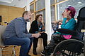Pflegekräfte im Gespräch mit einer Frau mit Rollstuhl